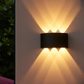 Waterproof aluminum LED outdoor wall lamp in matte black finish mounted on exterior house wall beside front door